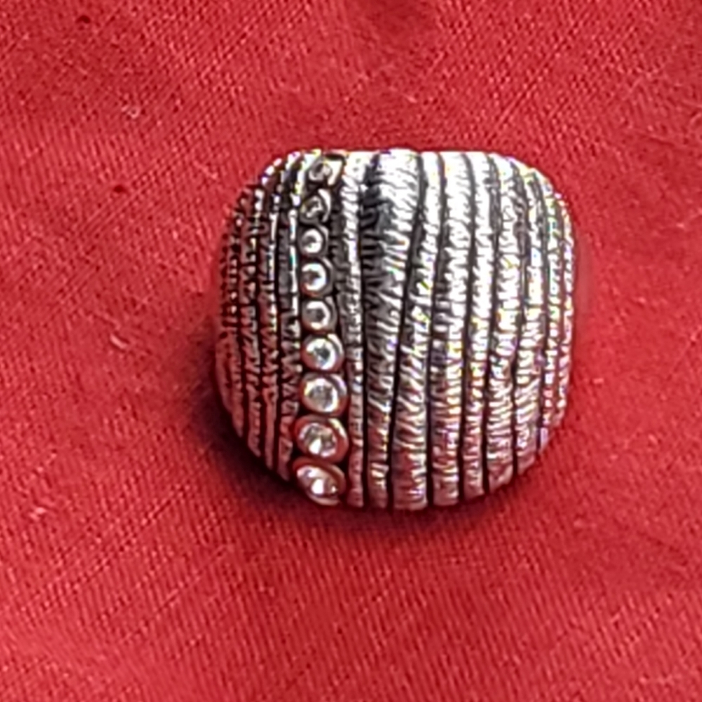Silver ring with rhinestones in the middle.